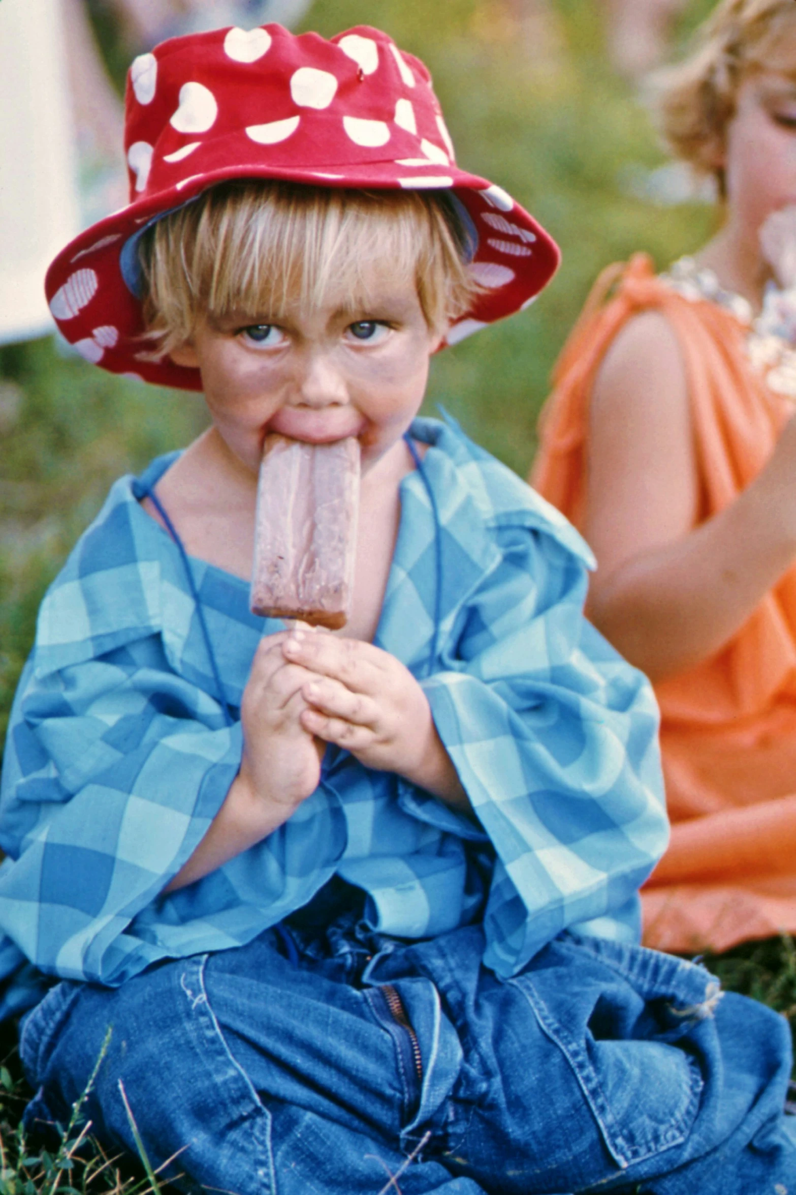 a boy wearing a hat eating an ice cream cone