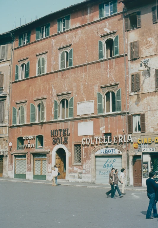 two men walking in front of an old building