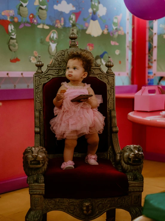 baby in pink tutu sitting on an ornate chair