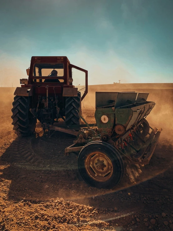 a tractor in the middle of a dusty field