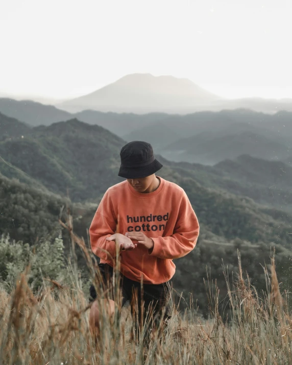 man in the mountains holding a plant in his hands