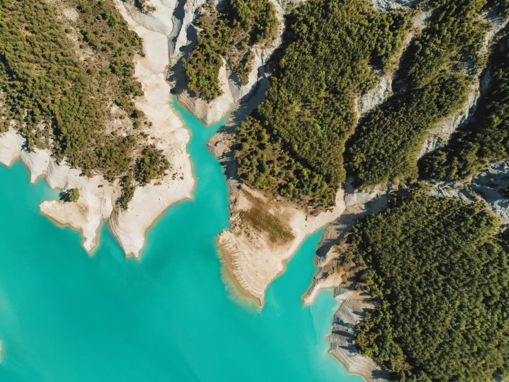 the view from the air looking down at the river running between two mountains