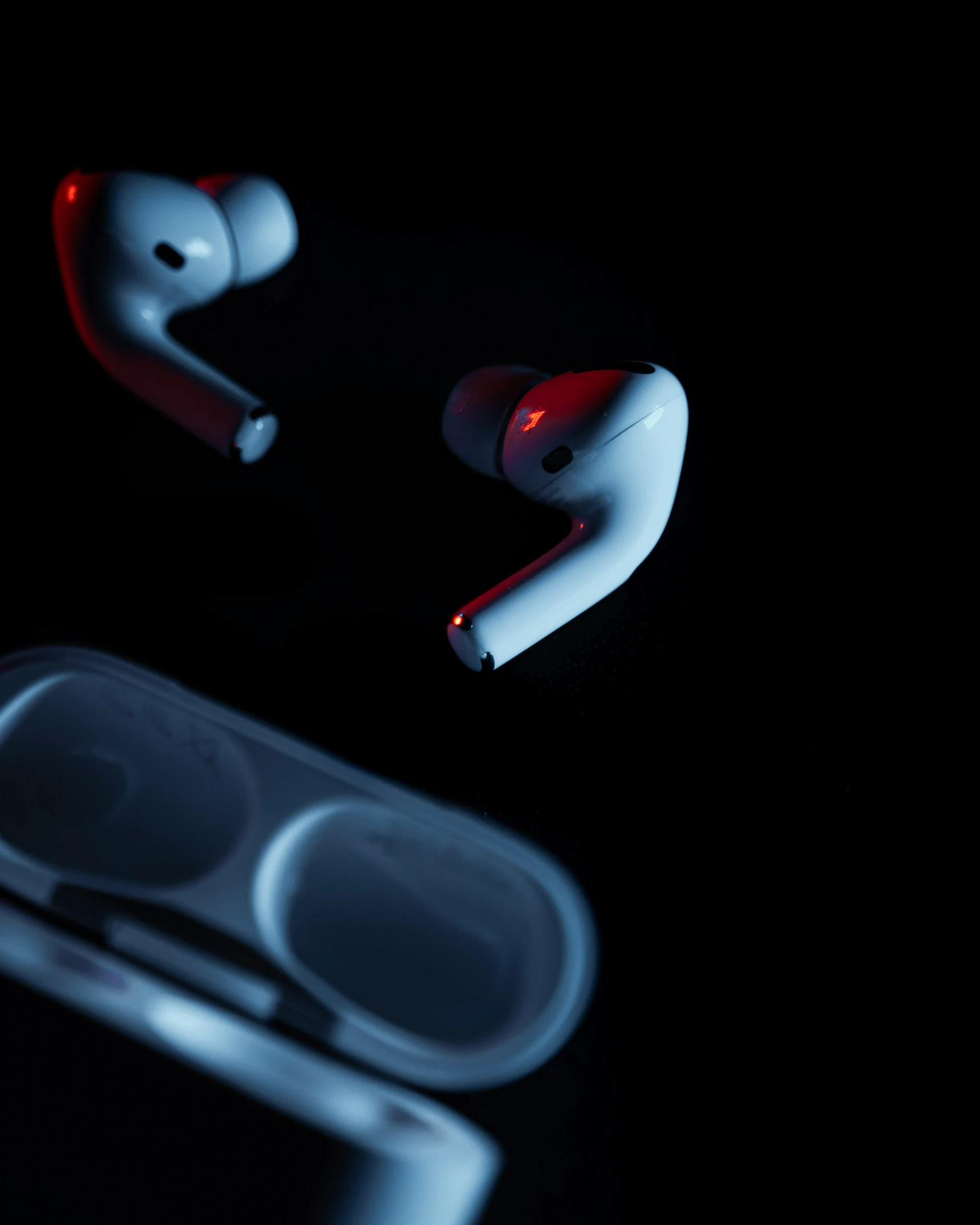 pair of red, white and black earbuds laying next to an iphone case