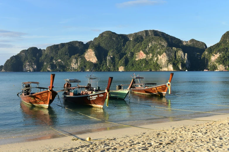 several small boats docked on the shoreline at low tide