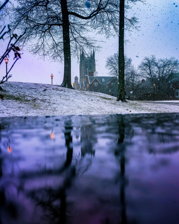 a church sits on a hill in the fog of snow