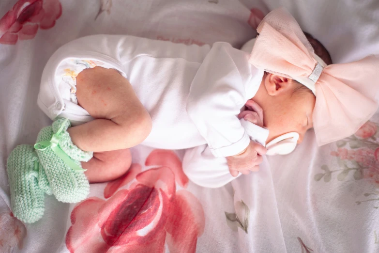 a newborn baby lying on a bed next to a hand puppet