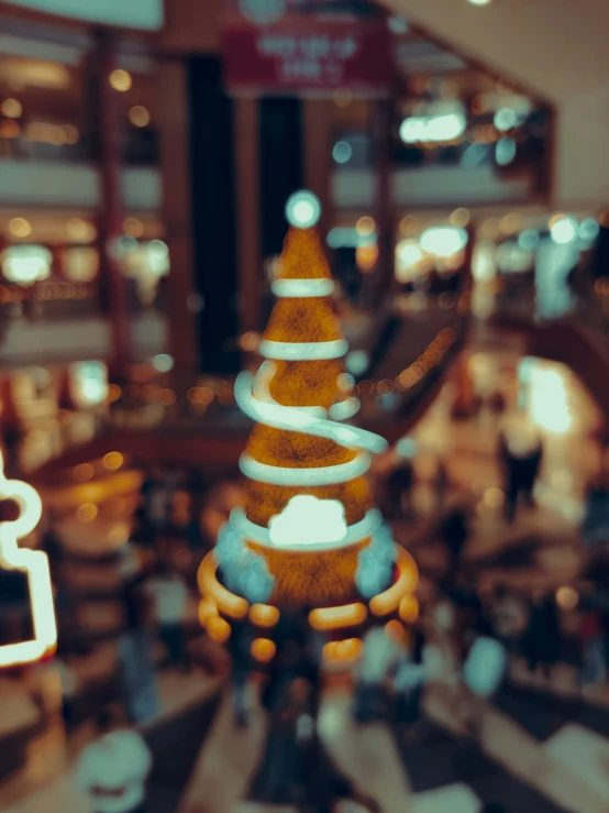 blurry image of an indoor shopping mall looking toward the escalators