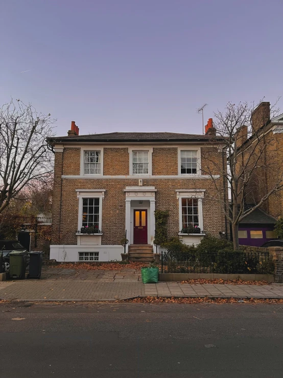 a home on the corner of a street with a house behind it