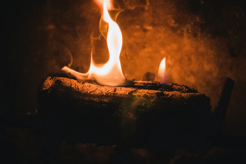 the flames of a match being made on a small piece of wood