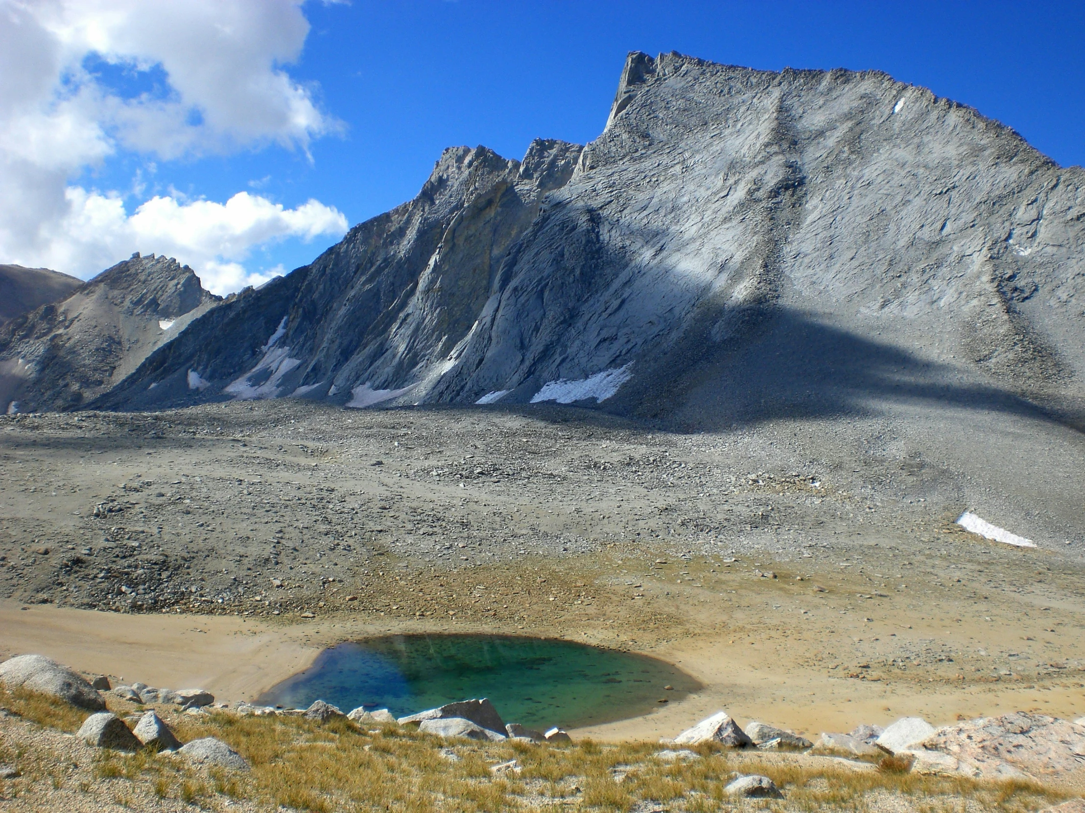 a blue pond sits in the rocky terrain