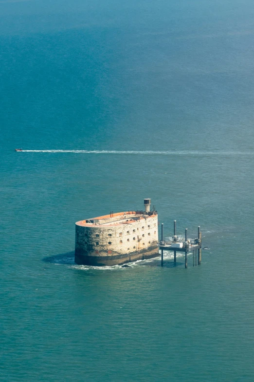 an old concrete lighthouse built in the middle of a body of water