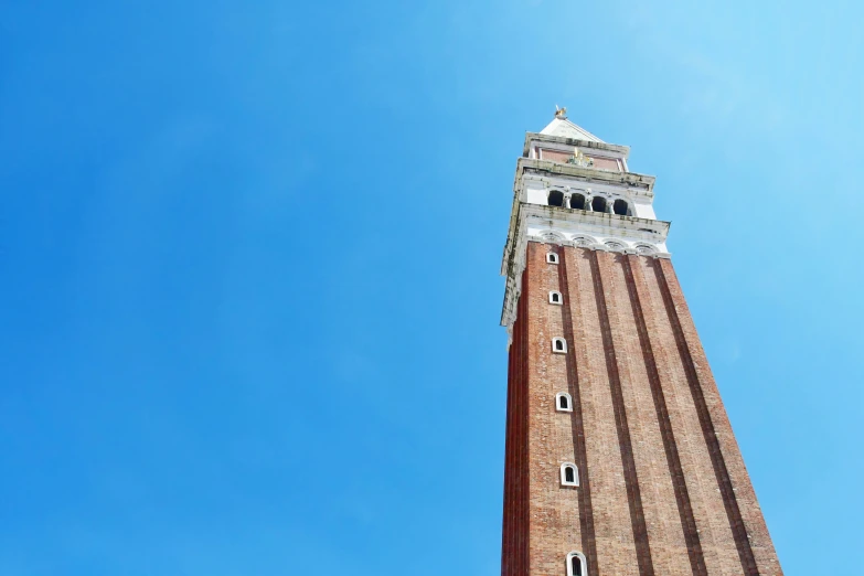 a tall brick clock tower with a white roof