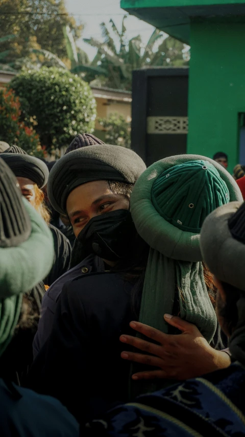 many people in winter hats, and scarves gathered together