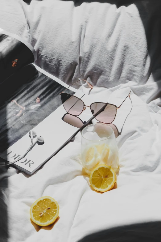 glasses and lemon slices are lying on a bed