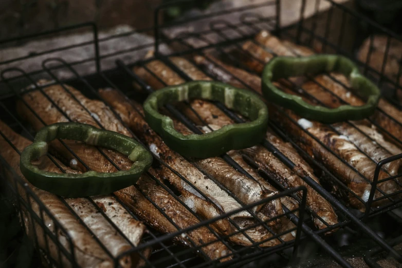 three green peppers sitting on top of grill racks