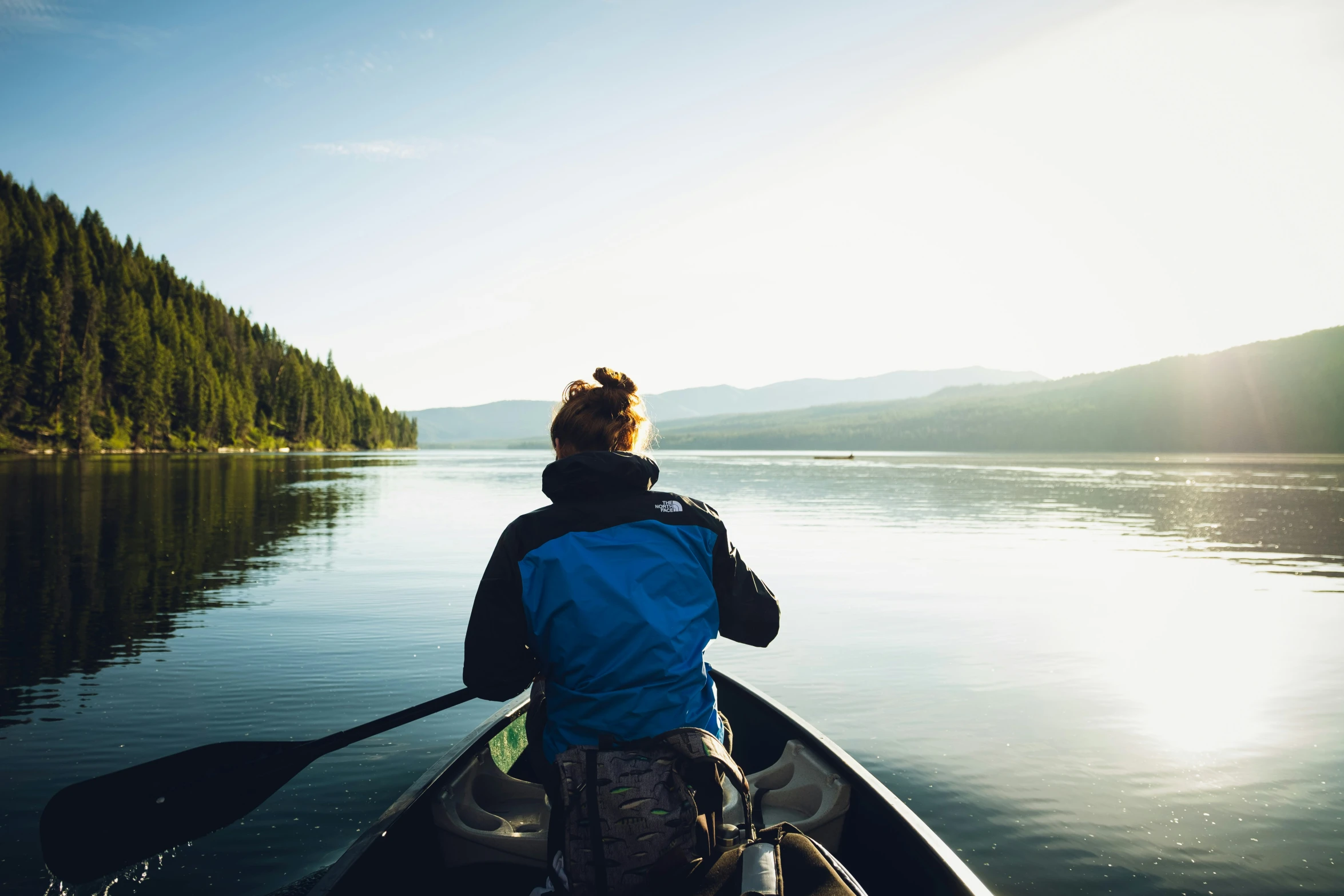 there is a person sitting on a canoe in the water