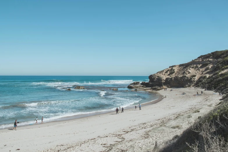 the beach with people walking around on it