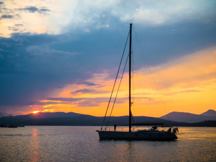 a boat traveling across a lake under a cloudy sky