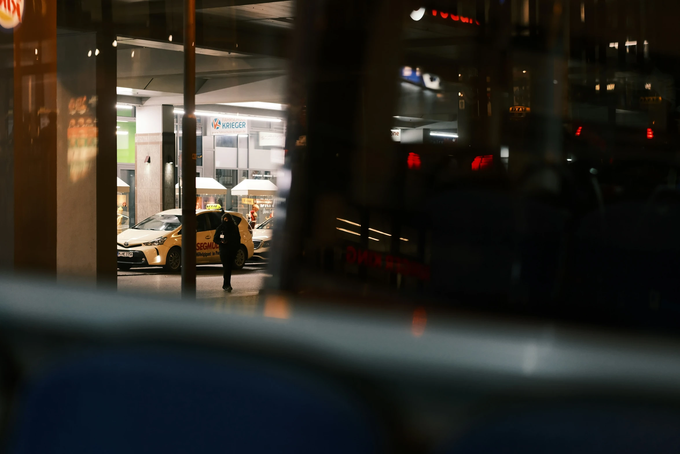 the reflection of a parked bus from inside a building