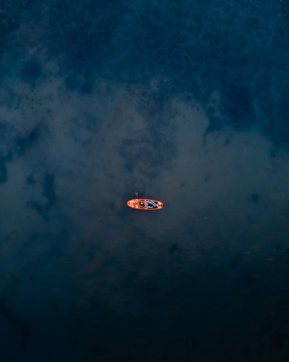 a paddle boat floats close to a larger one on a body of water