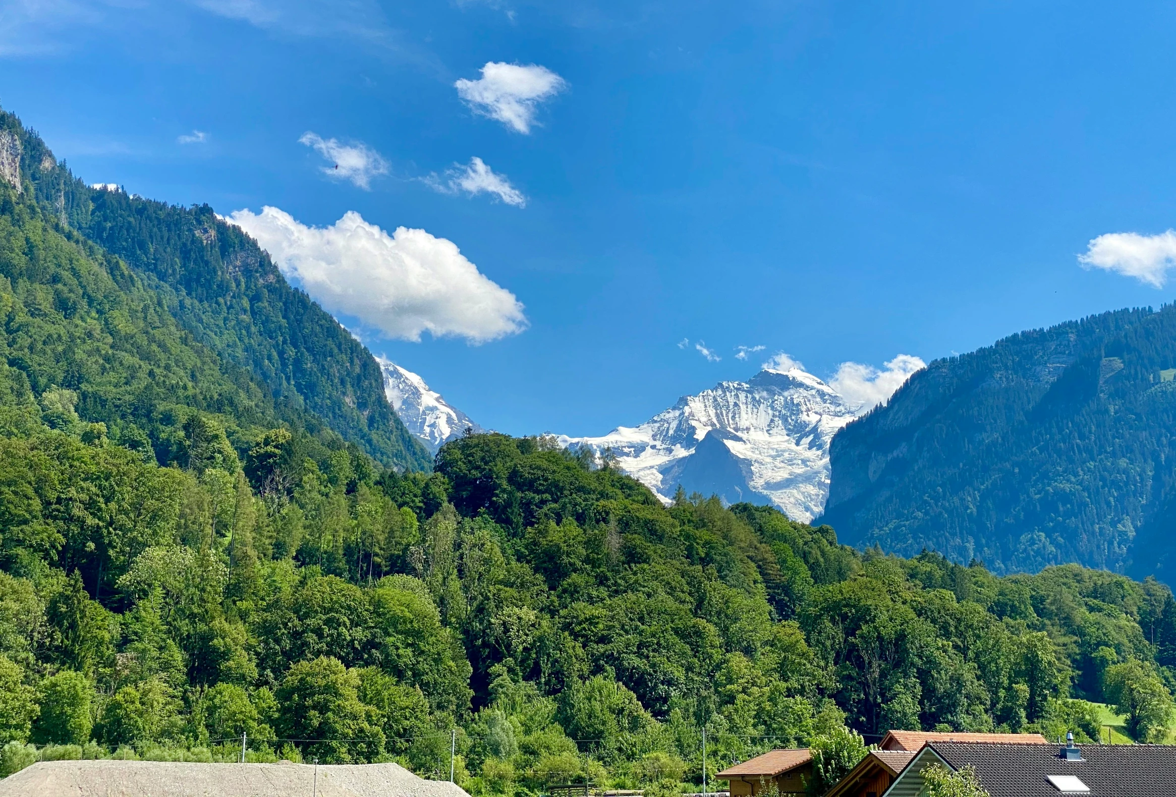 mountains are seen near a village in the foreground