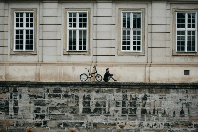there is a man riding his bicycle next to a building