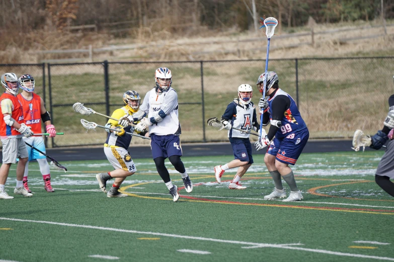 a group of young people playing lacrosse in a field