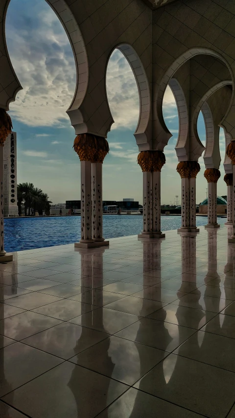 columns and arches are shown in front of a swimming pool