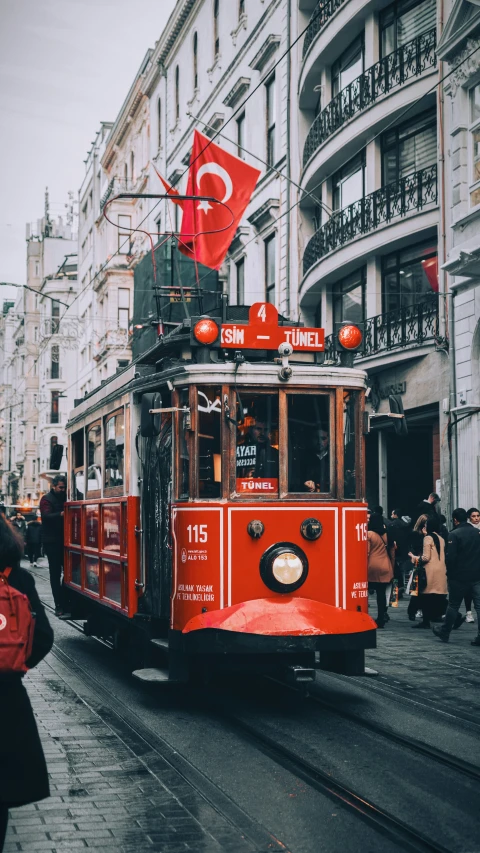 the trolley car is carrying passengers on the streets