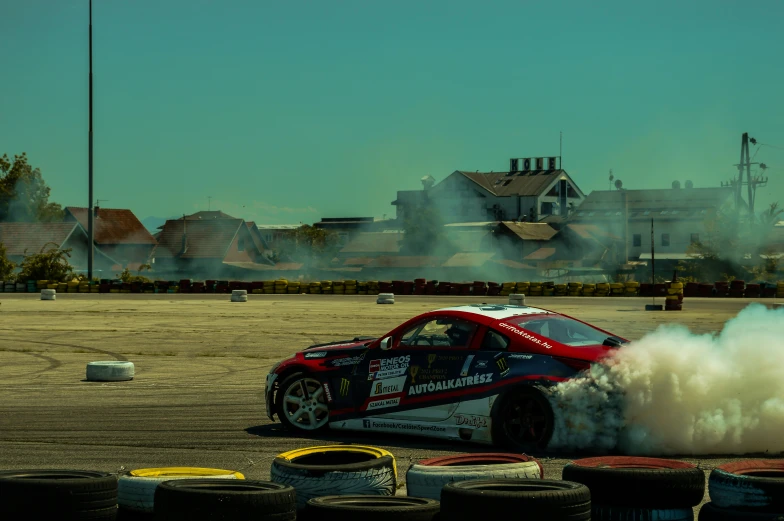 a red and black car has smoke from its exhaust