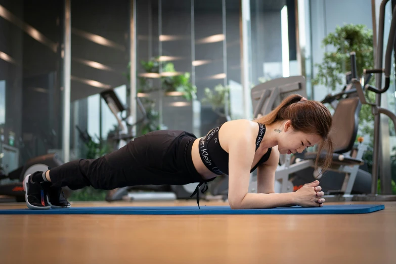 woman doing plankes on a mat in the gym
