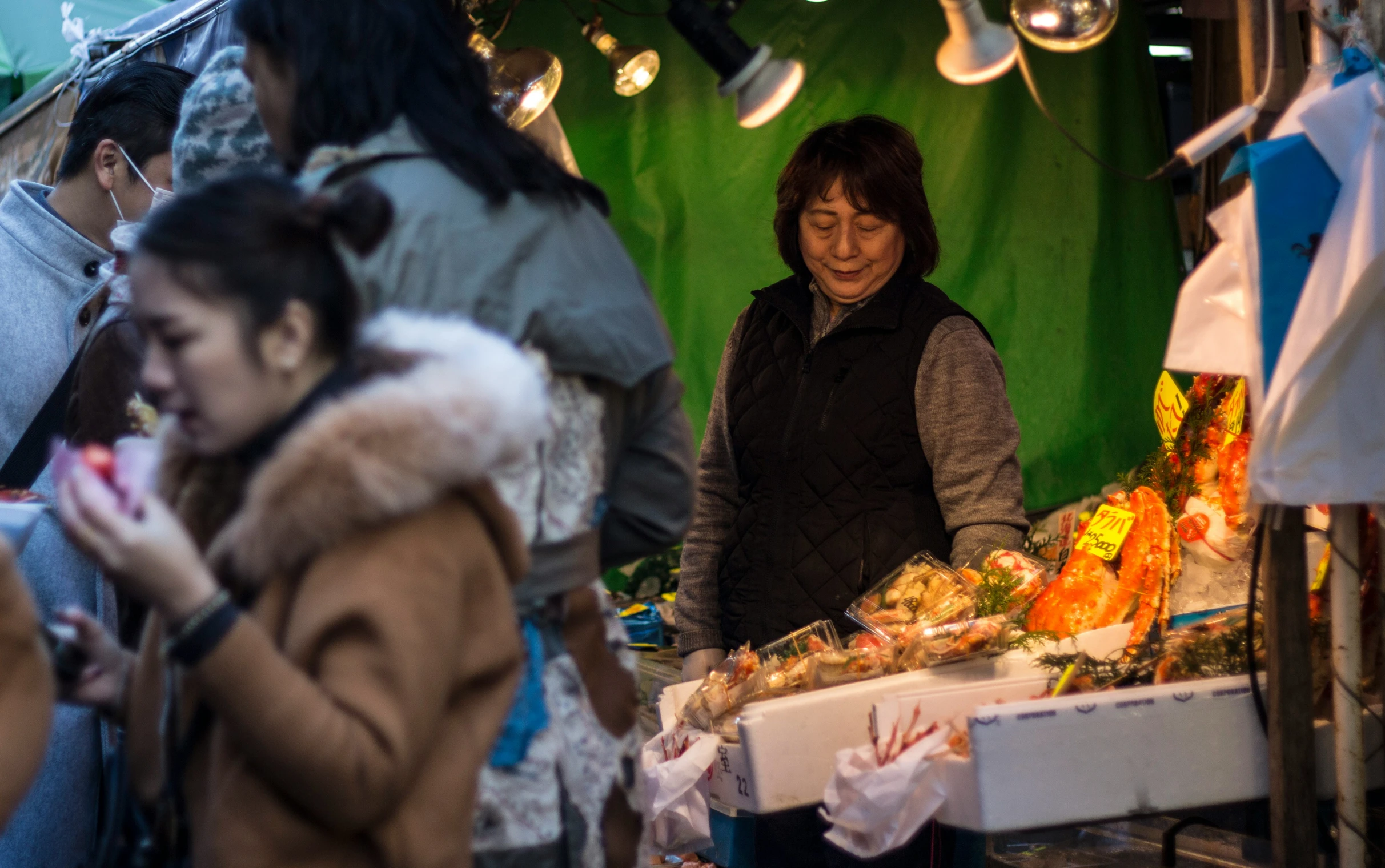 a woman at a market is busy with customers