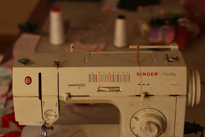 an old sewing machine is hooked up with several different spools