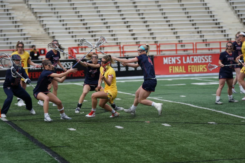 a group of girls playing lacrosse against each other on a soccer field