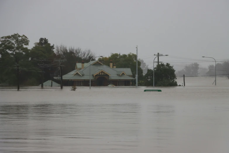 water flooded across a parking lot near a house