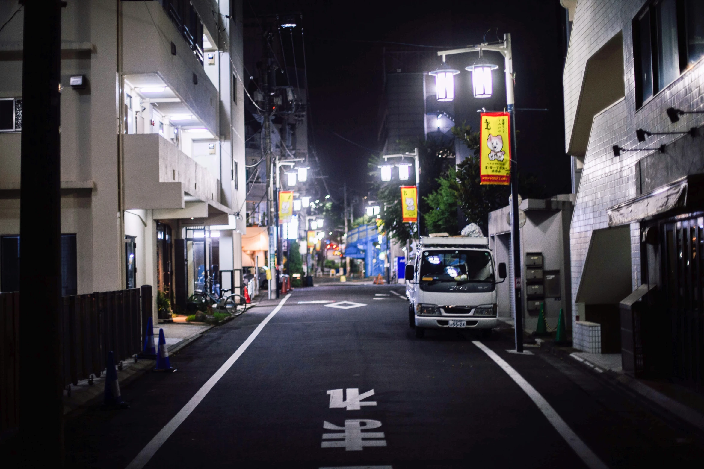 a small city street at night with a van parked