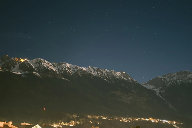 the view of mountains with stars and some buildings