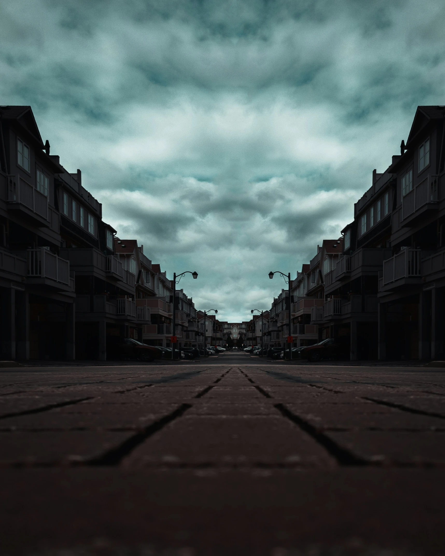 an empty sidewalk in a residential area with high rise buildings in the background