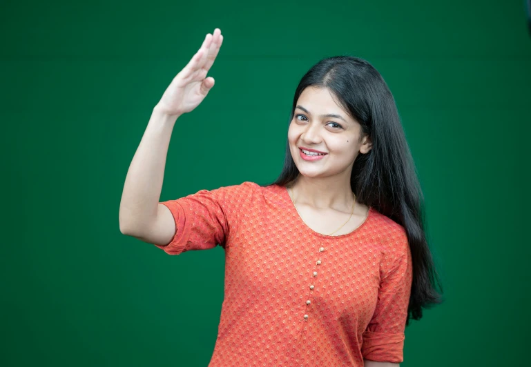 woman in orange top holding out her hand