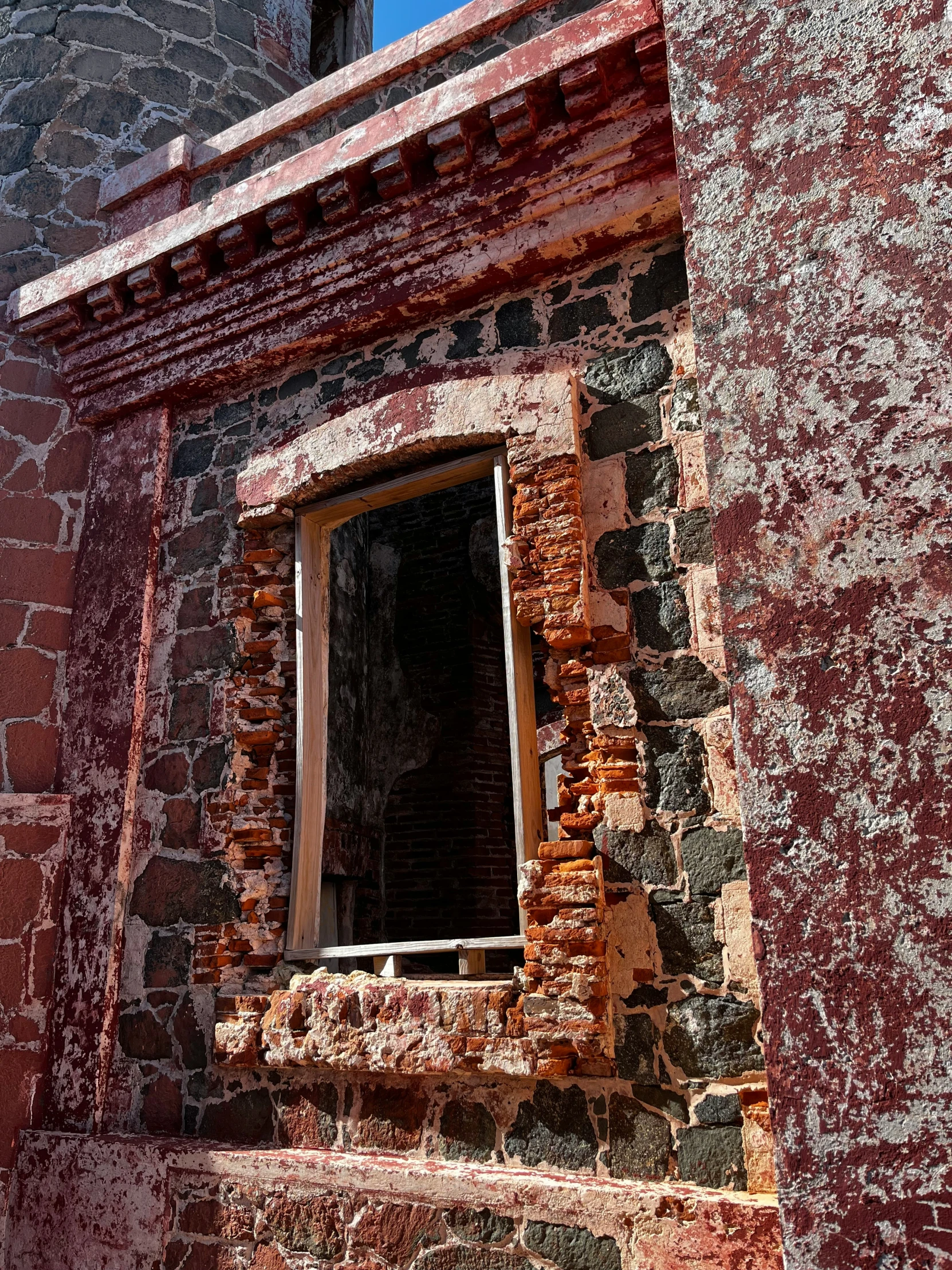 an old, crumbling brick building with a stained window