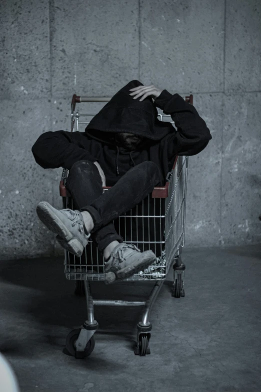 a person in black jacket in shopping cart with their head up