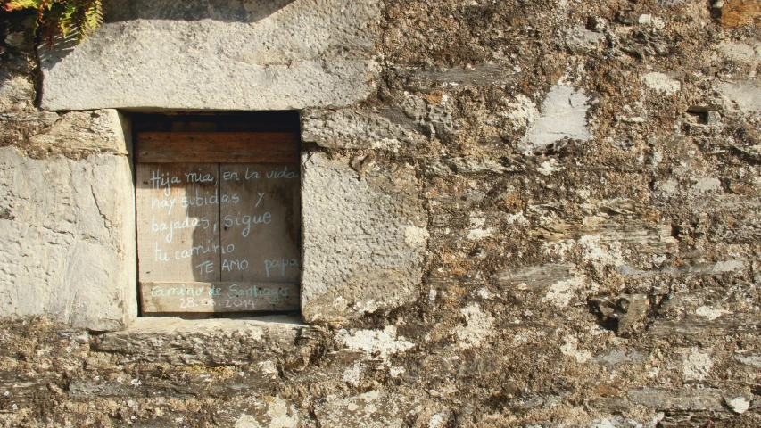 a window on a concrete wall with graffiti