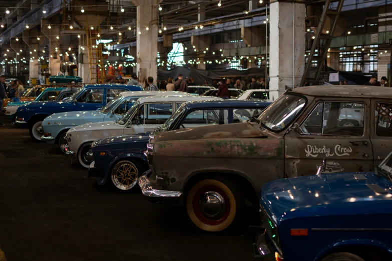 various colored old vehicles in a very big building