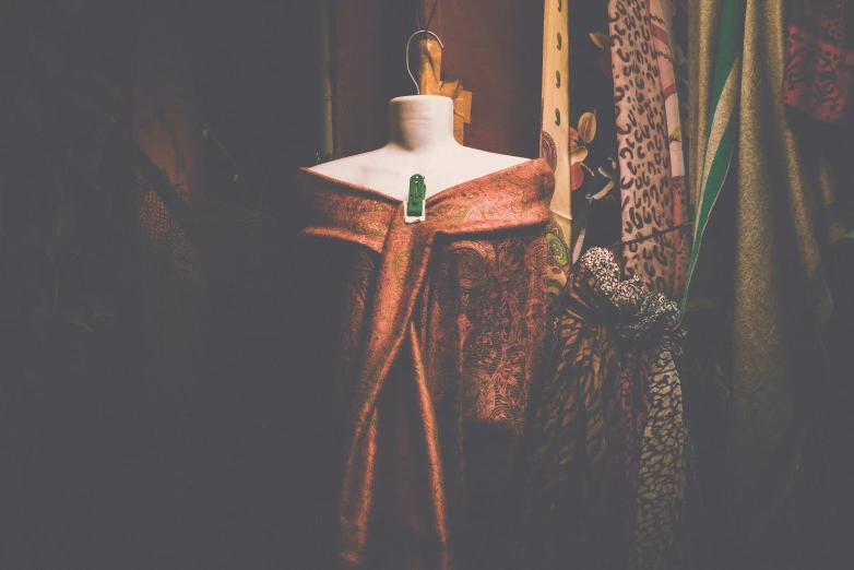 a dummy standing next to a curtain with a brown ribbon around it