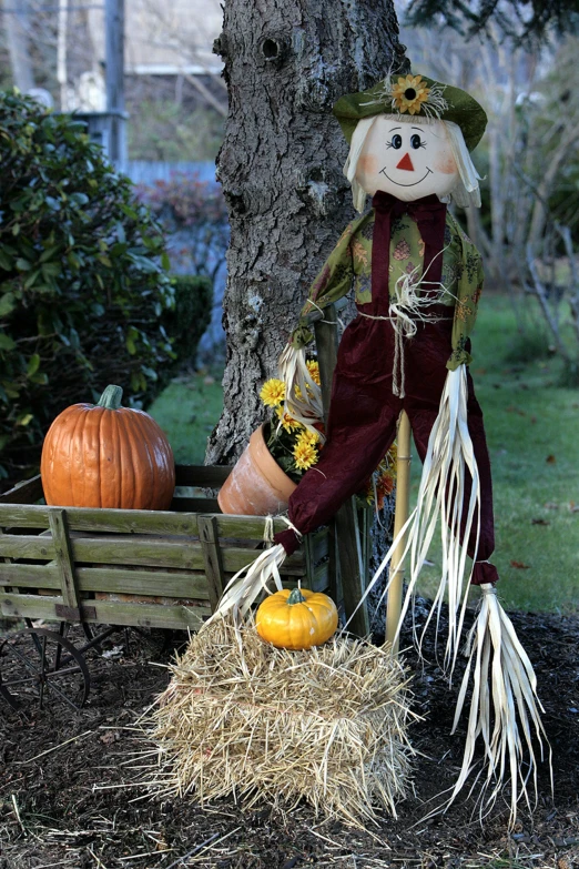 a scarecrow doll next to a pumpkin