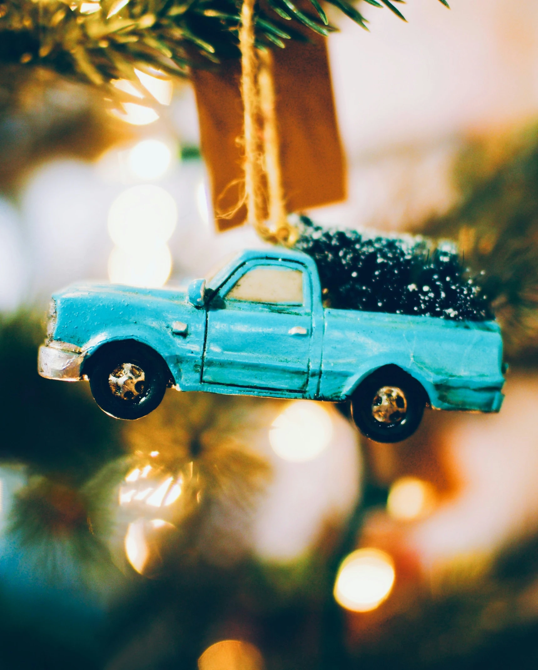 a truck hanging from a christmas tree with lights in the background