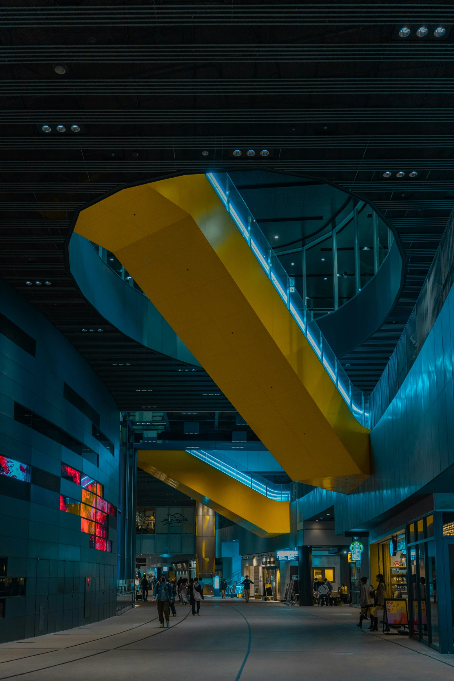 a yellow and blue art piece hanging in the middle of a lobby