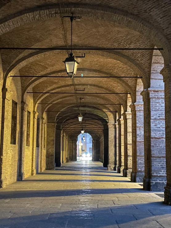 a long hallway that is very large and lined with brick arches