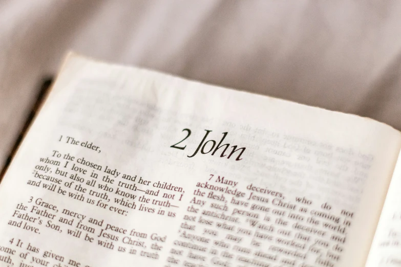 an open bible on a cloth with words printed on it