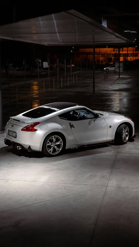 a white sports car parked at night on the concrete